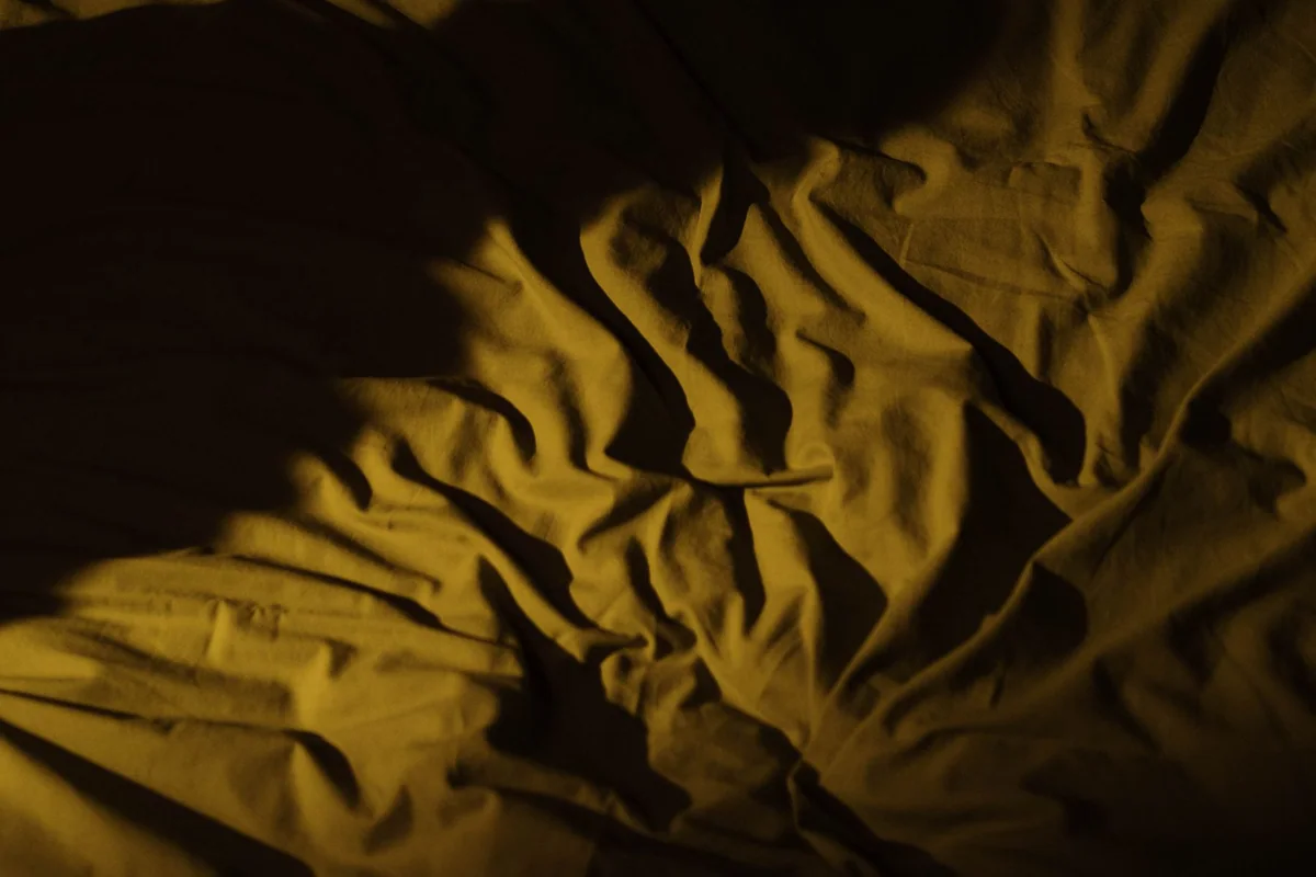 A folded quilt and clean bedding ready for guest turnover